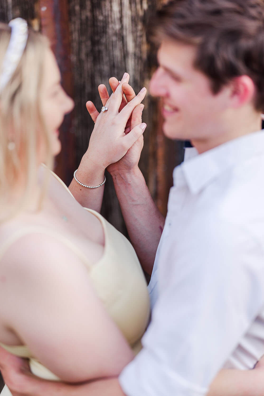 close up shot of an engaged couple's hands interwined showing off a diamond engagement ring