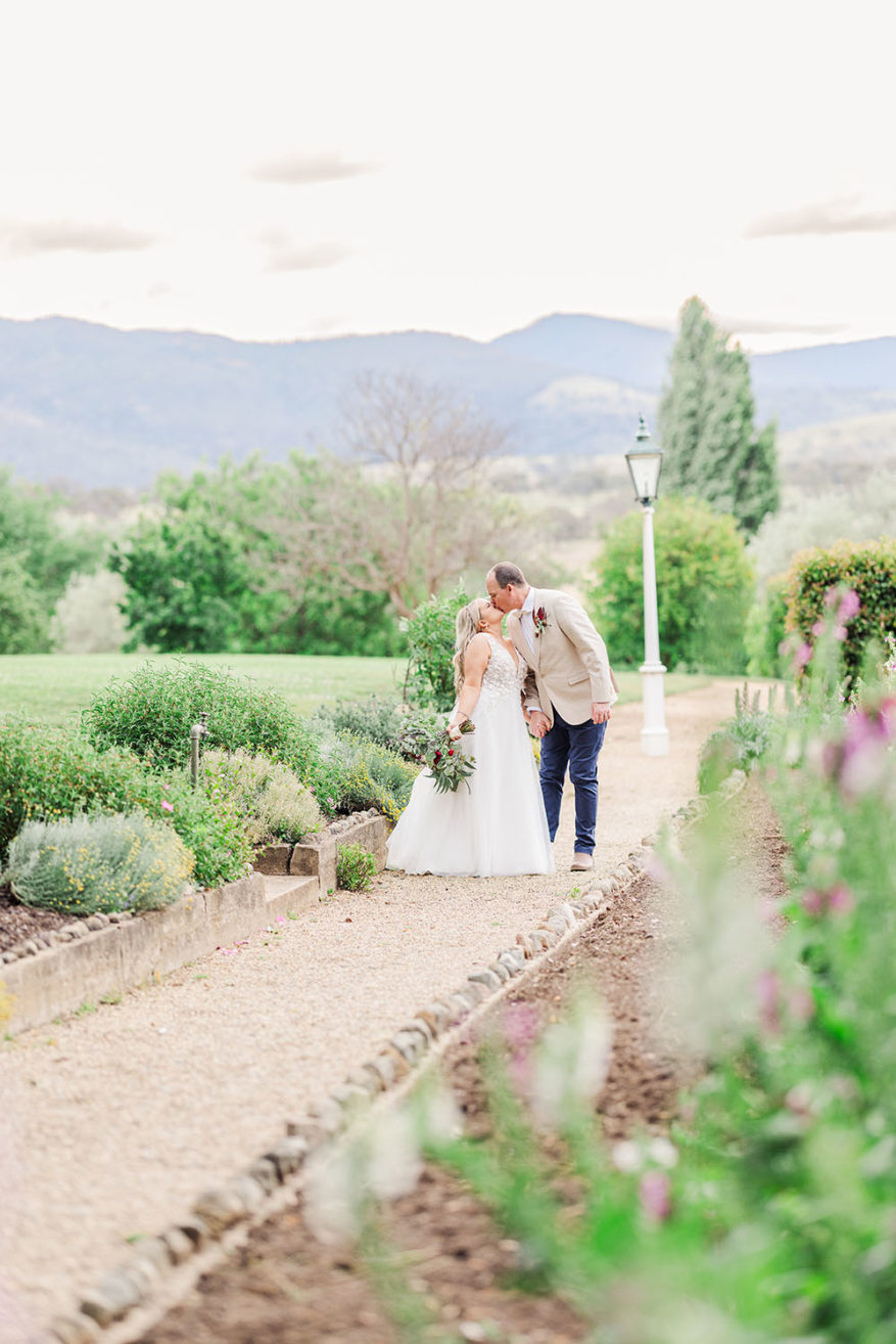 bride and groom standing in the gardens of lanyon homestead