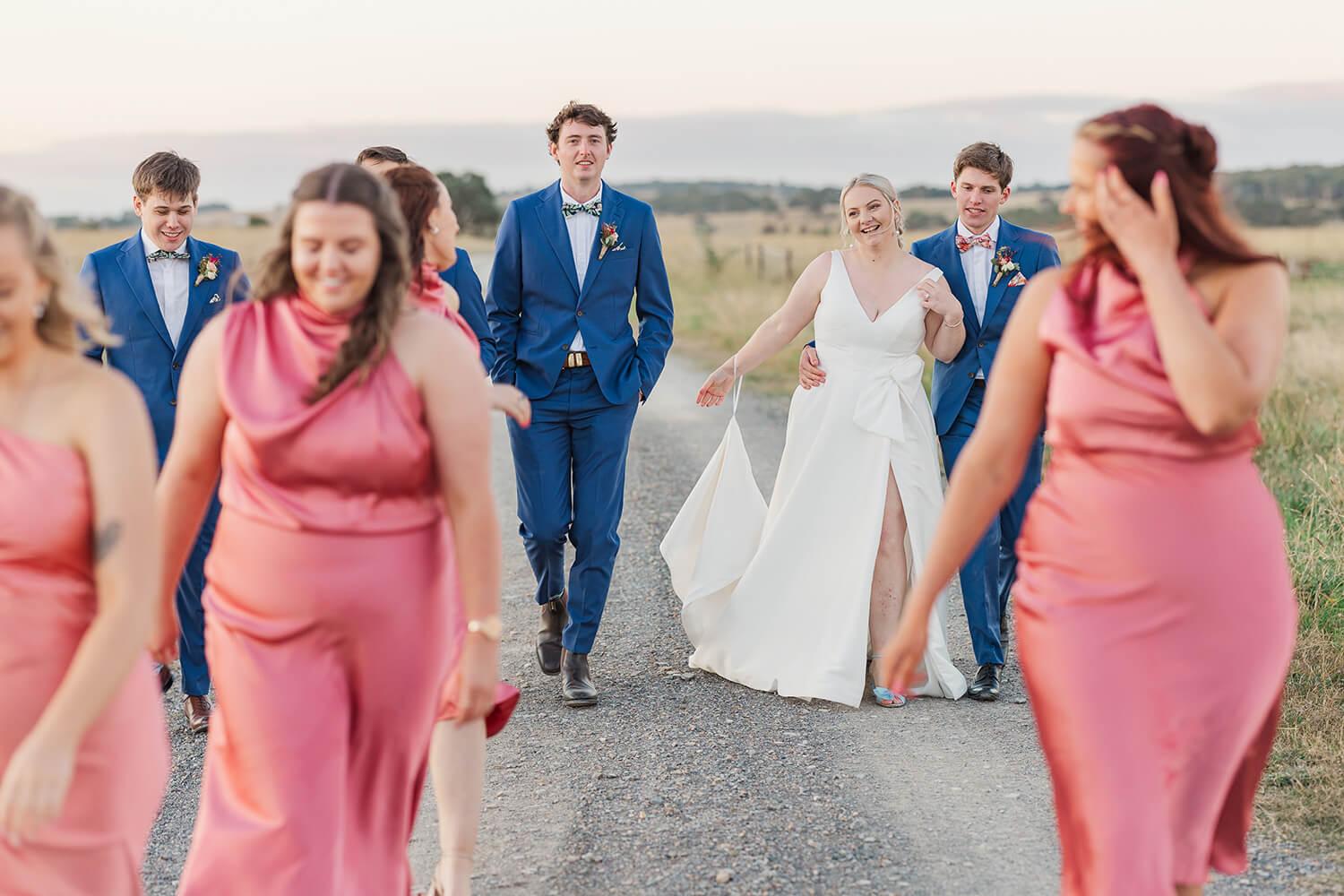 bride and groom walking among their bridal party