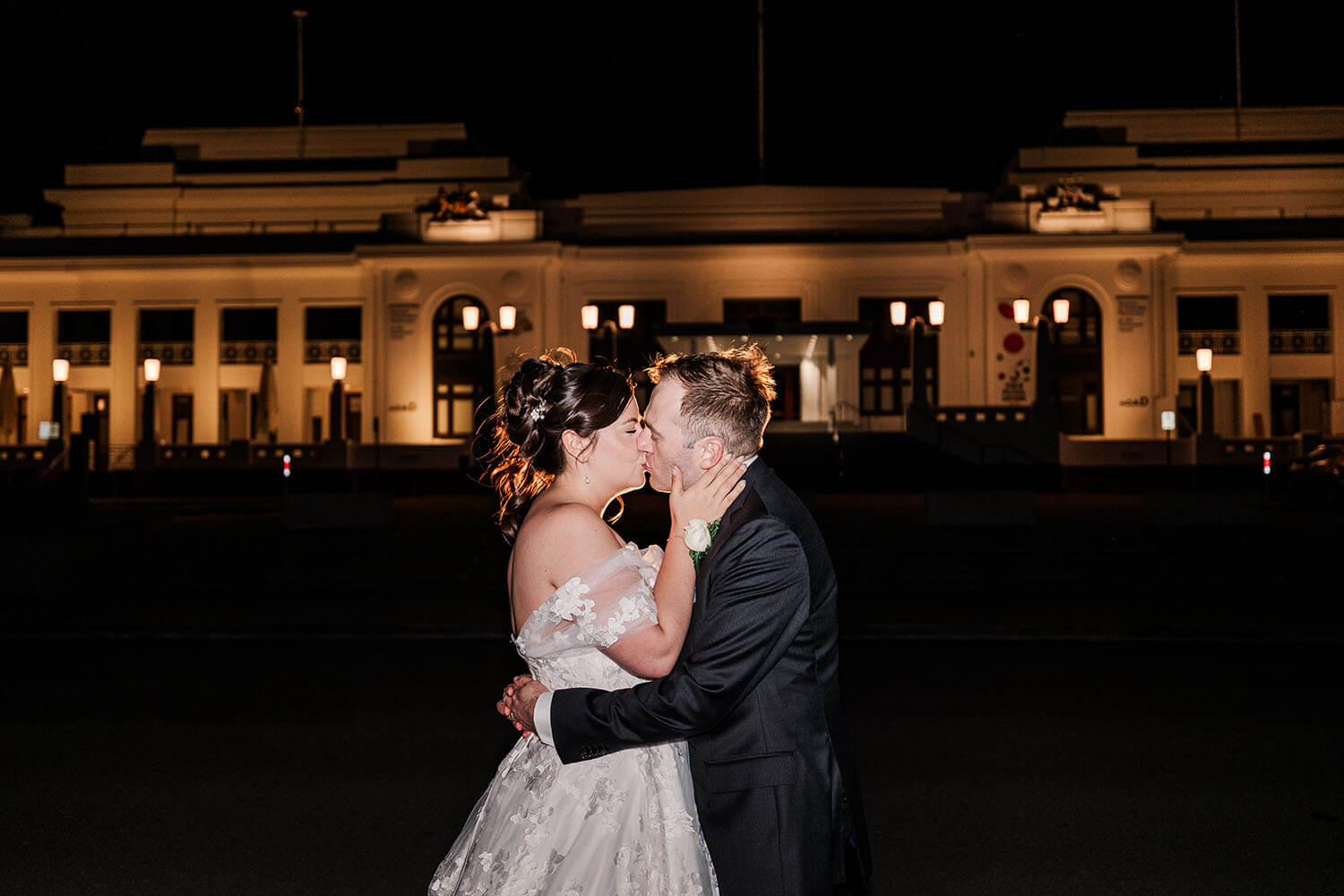 bride and groom kissing outside the Old Parliament House in Canberra at night