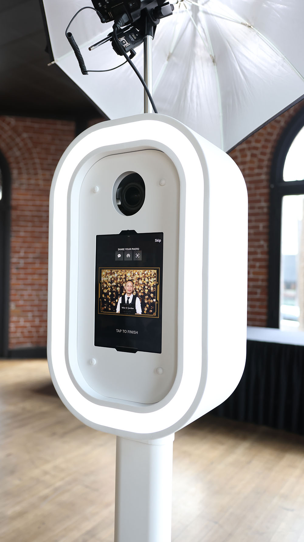 close up of a white photo booth with ipad and flash on top